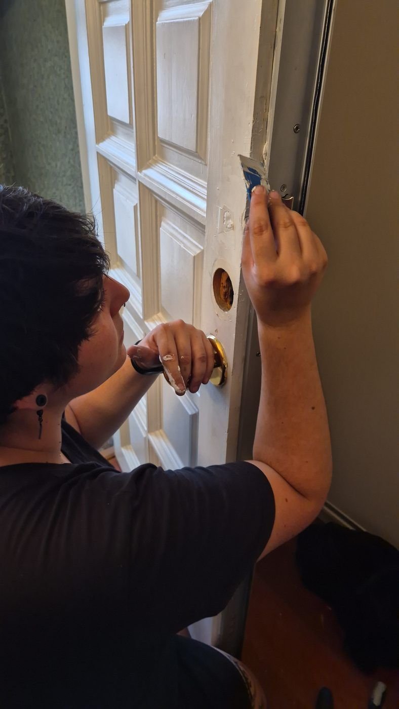 Profesional revisando el canto de una puerta blanca durante una apertura