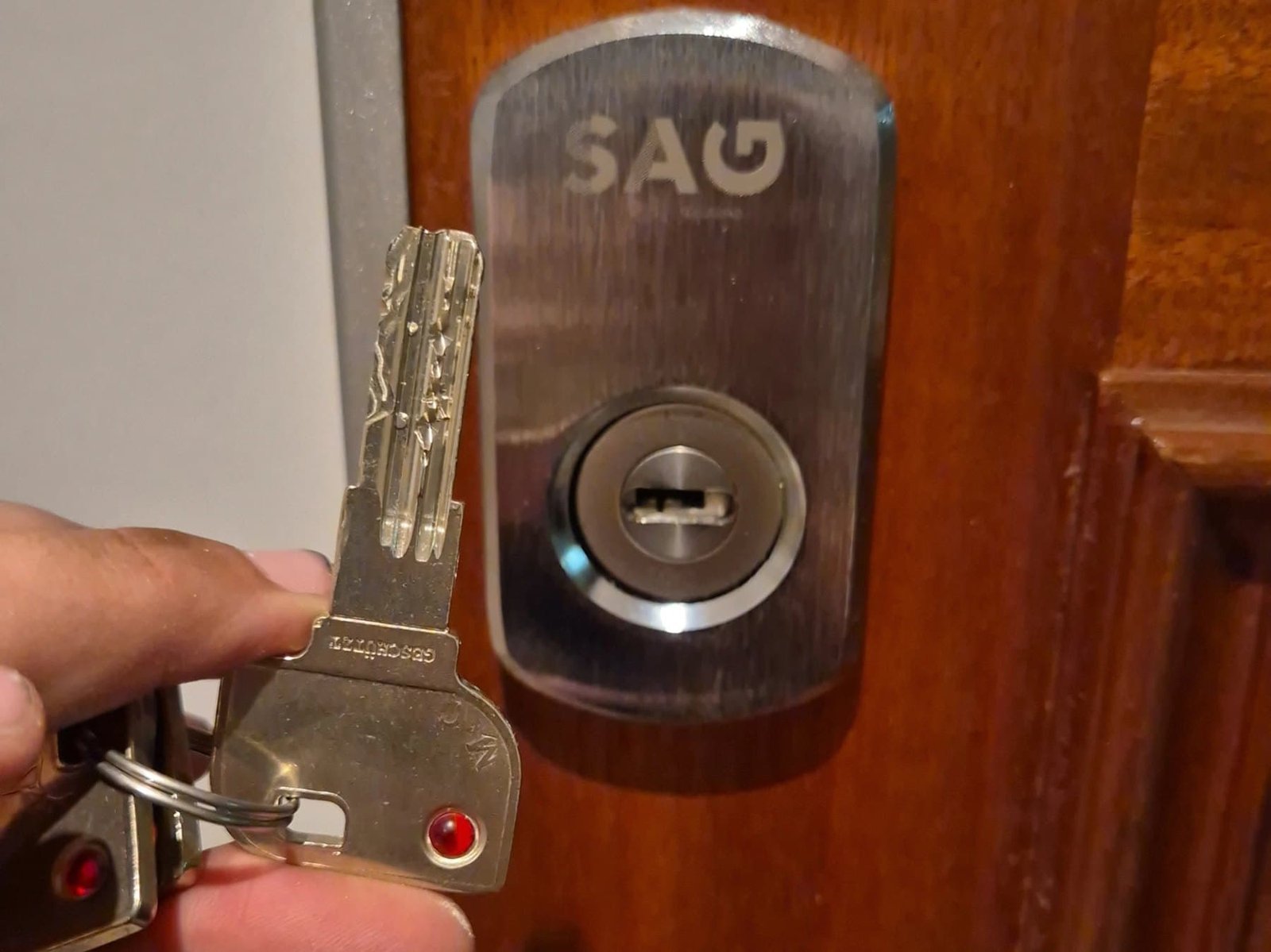 Escudo de seguridad SAG instalado en una puerta de madera con la llave puesta